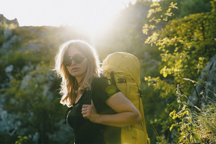 Woman wears Heron Mountain sunglasses for hiking in alpine sunshine