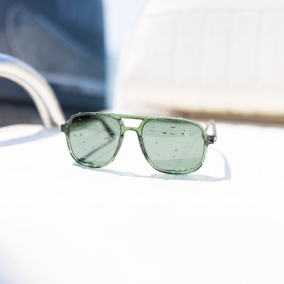 Howlin' sunglasses in green on the back of a boat