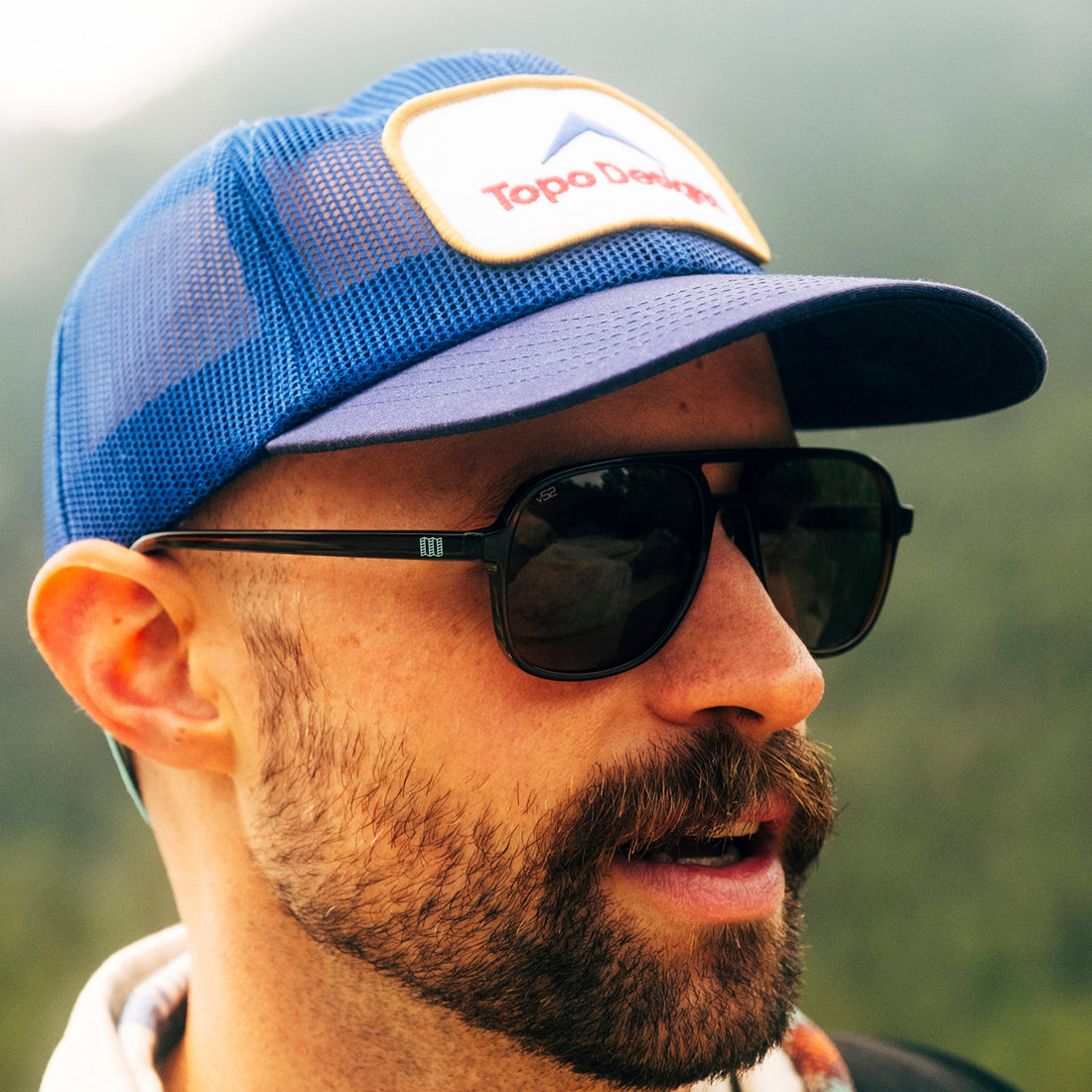 Man wears Topo Edition Howlin' sunglasses from VALLON with a Topo Designs cap