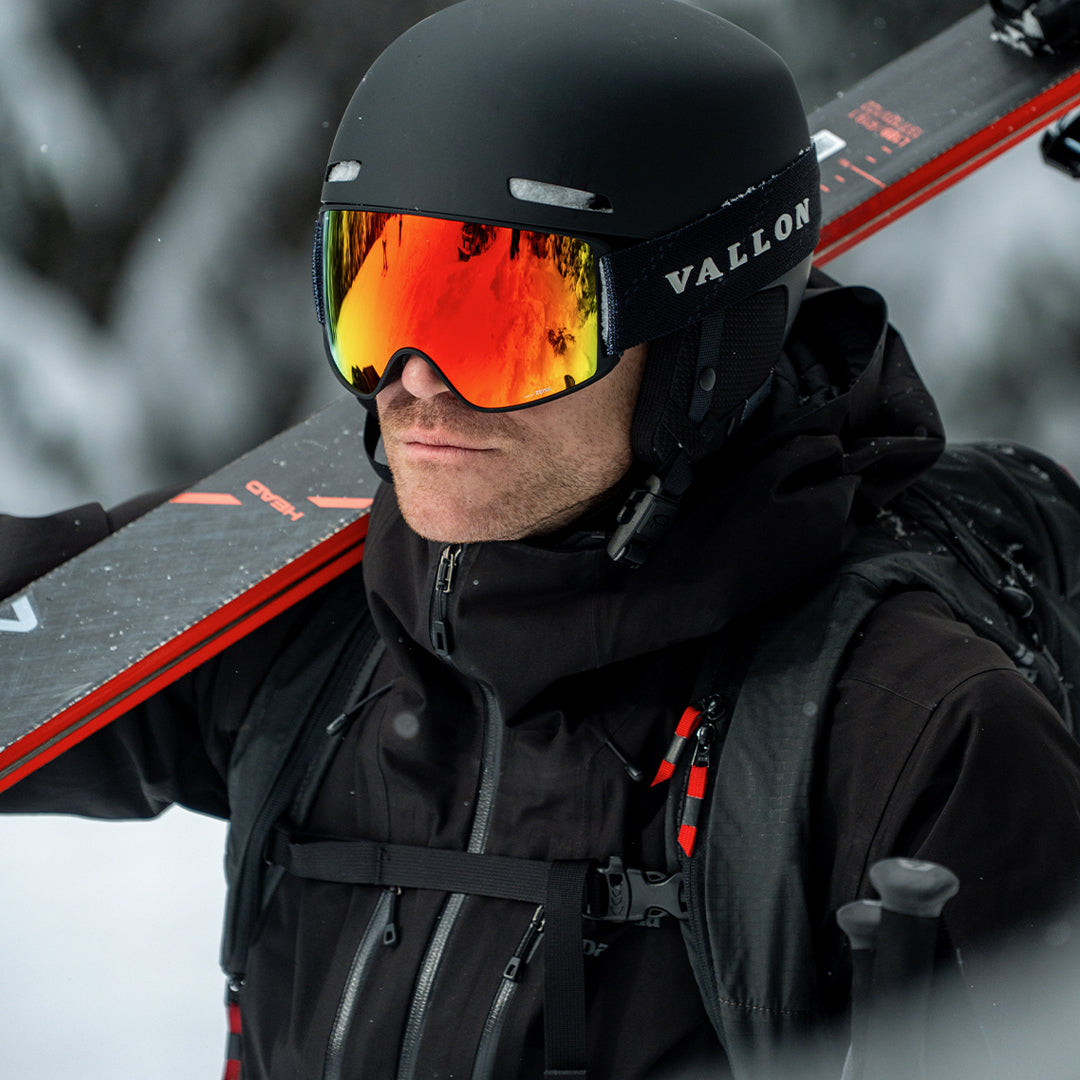 Male skier wears Black Orange High-performance Crossroads ski goggles from VALLON with ZEISS toric lens and orange lens coating