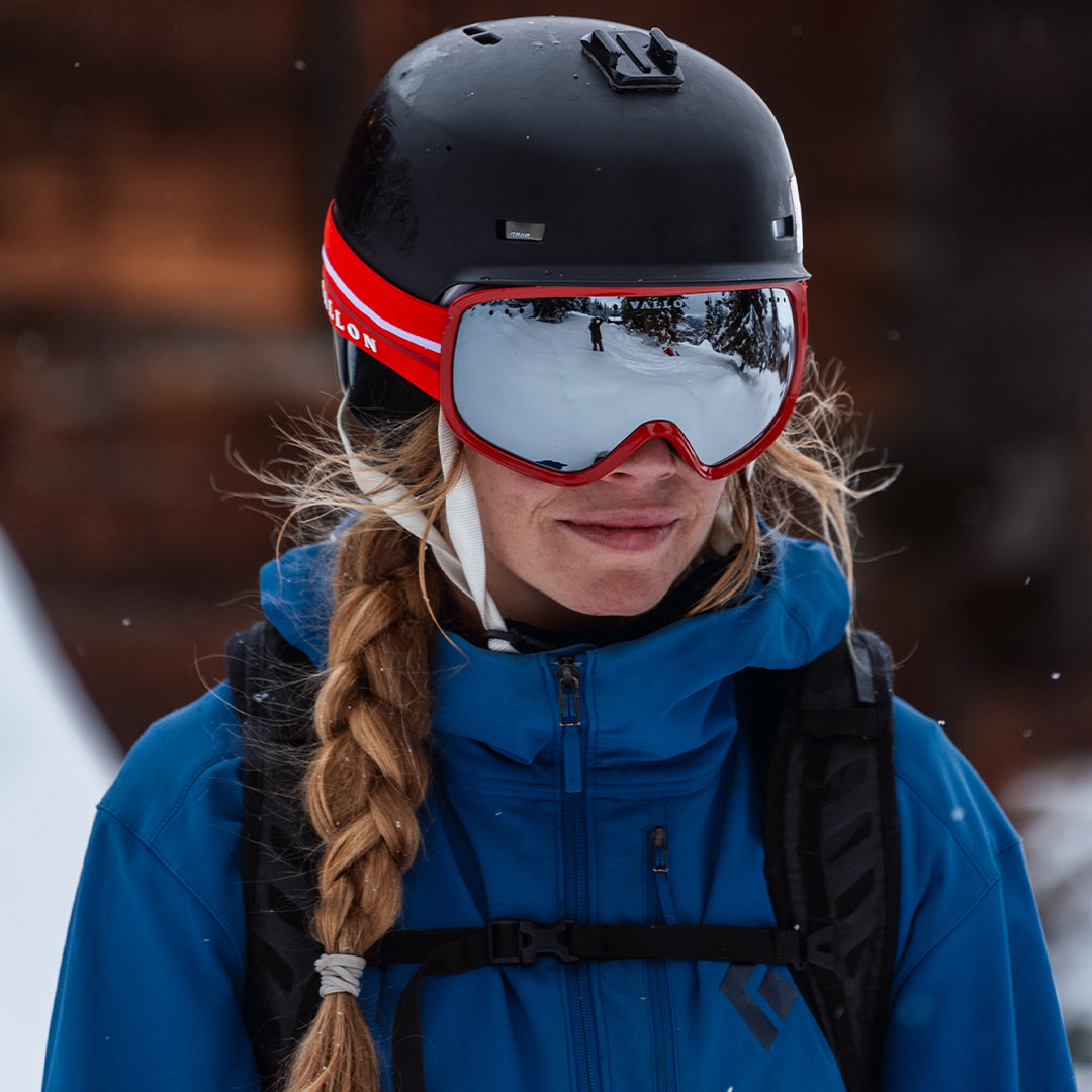 Woman wears VALLON 80s-inspired retro Freebirds goggles for snowboarding in Red-Silver