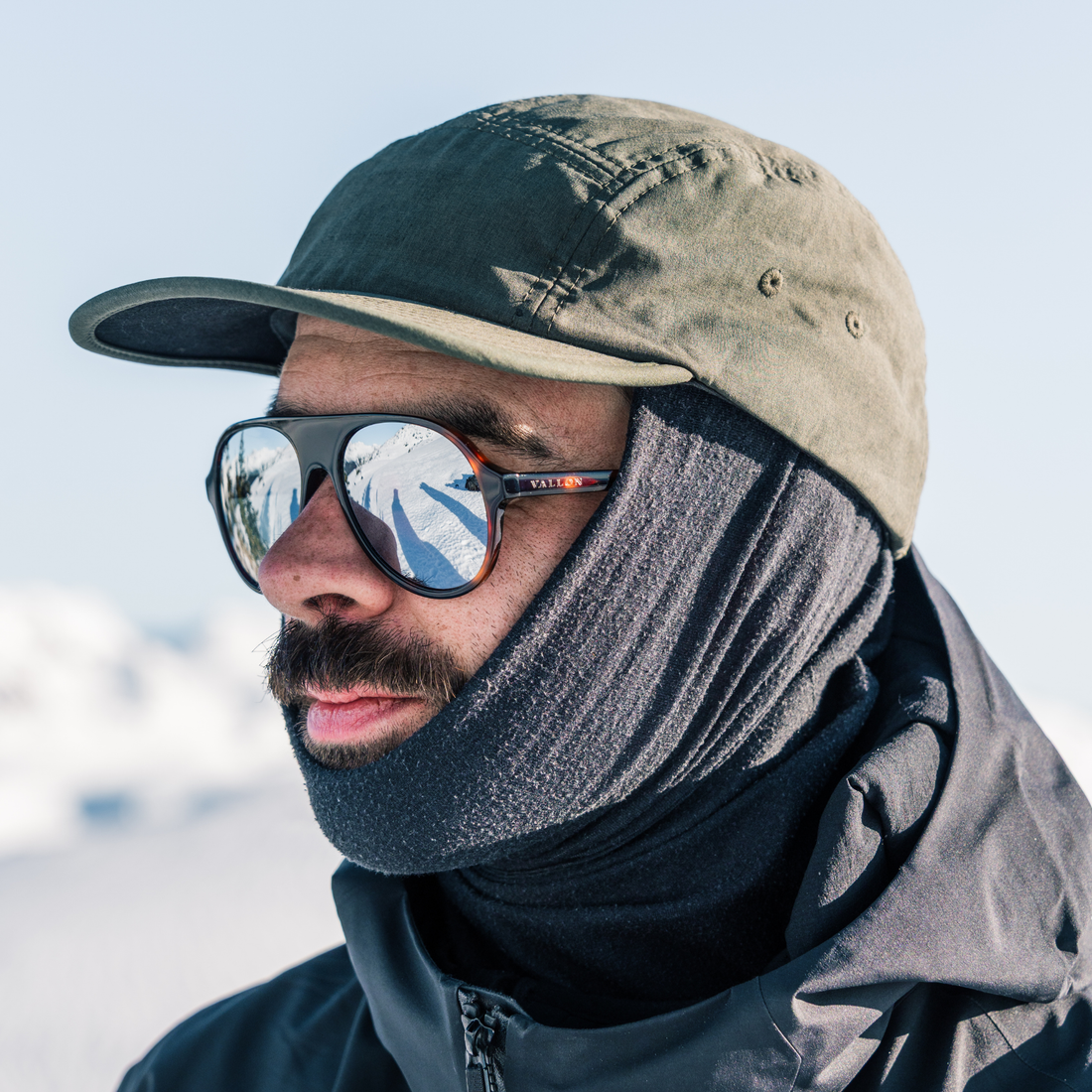 Man wears VALLON 80s-inspired Hazlewood sunglasses with full-mirror V52 lenses for skiing in bright sunshine