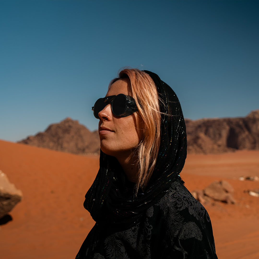 Woman wears Heron Desert sunglasses from VALLON while trekking in Jordan