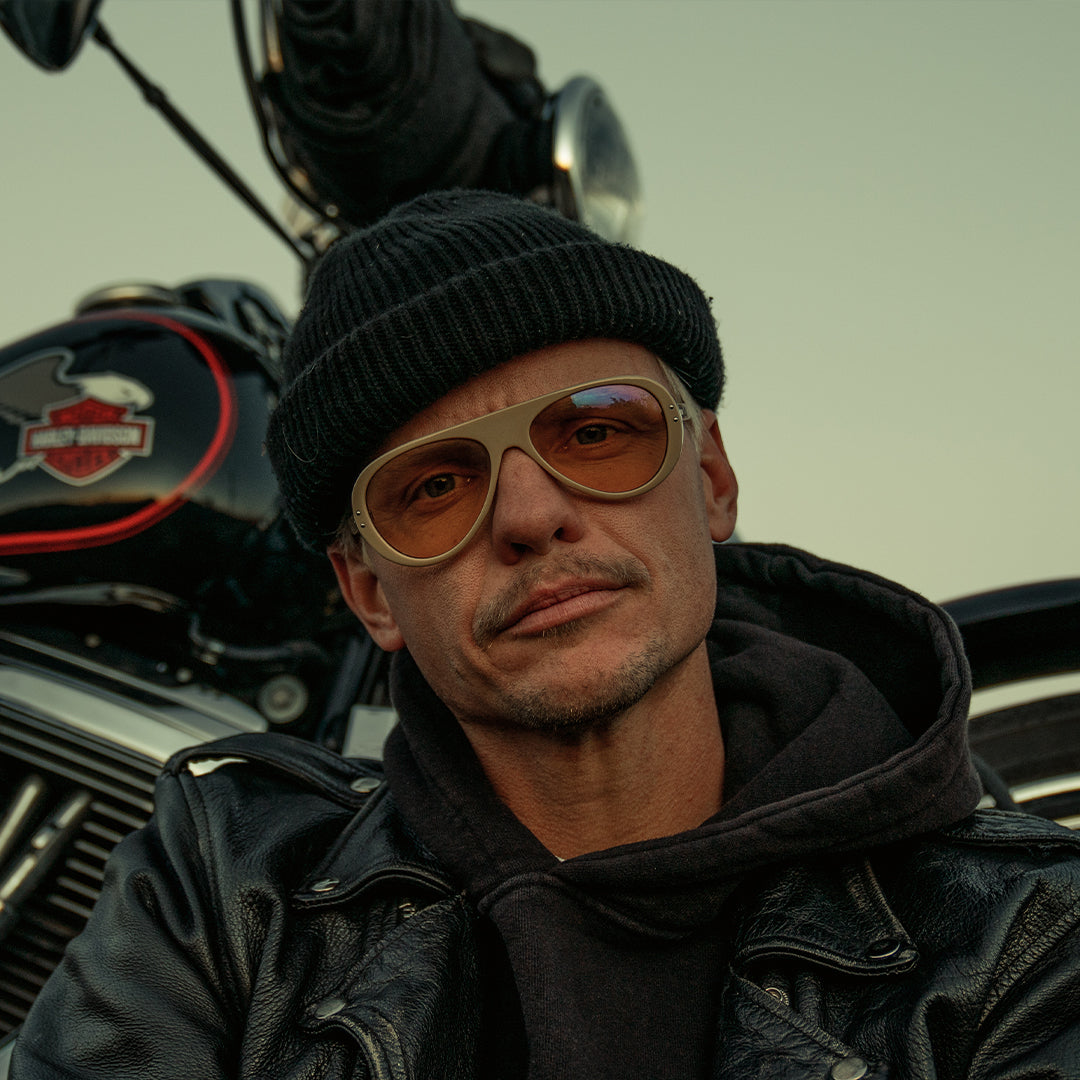Man wears VALLON Moto Aviators sunglasses sitting in front of a retro motorbike