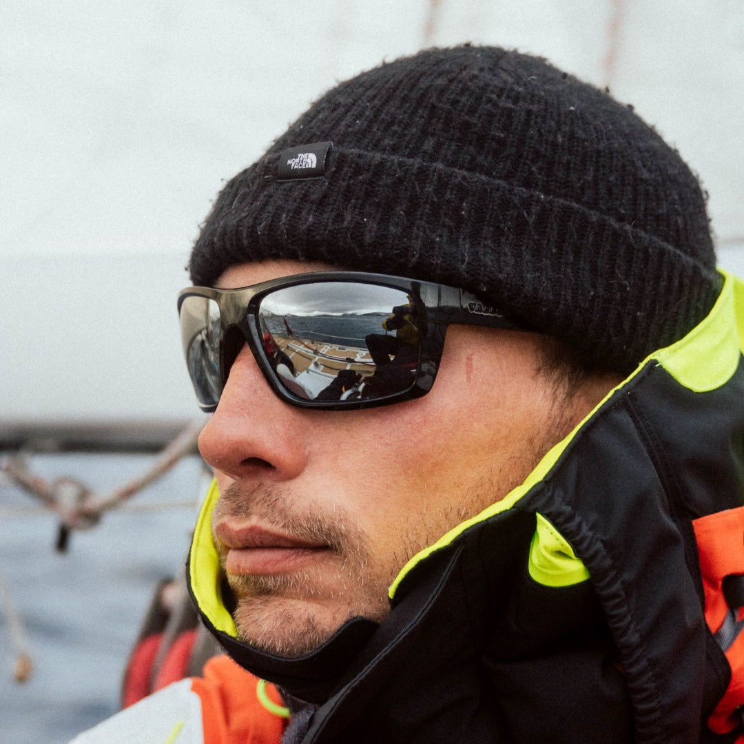 Man wears VALLON Saltwater Revivals sunglasses on a boat in winter