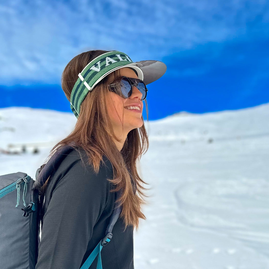 Woman wears VALLON Vizor in bright snowy landscape for sun protection