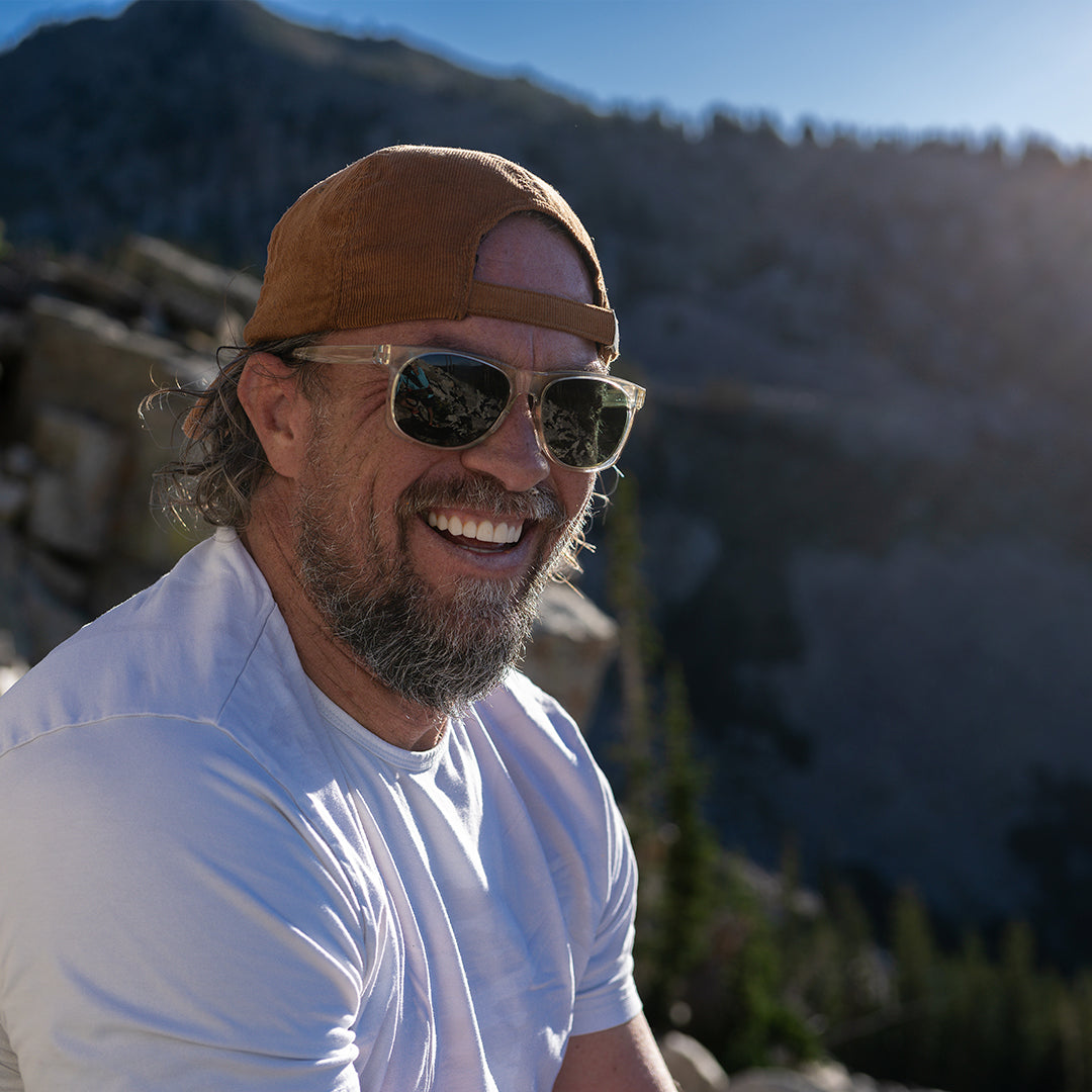 Man wears Ventures sports sunglasses in Sage with V52 optics and sustainable lightweight frame in the mountains