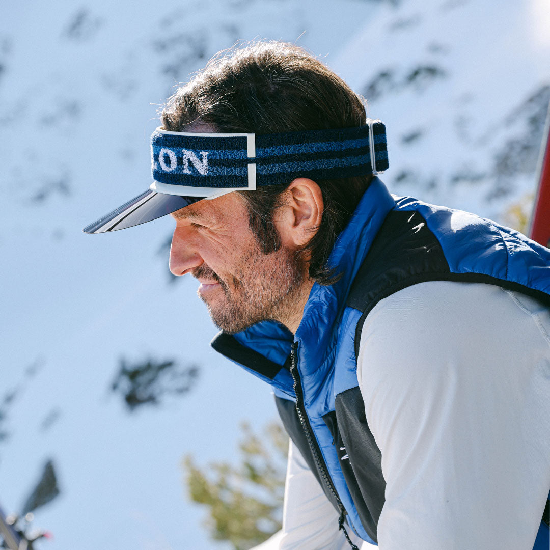 Man wears VALLON Vizor in blue for sun protection on bright winter day