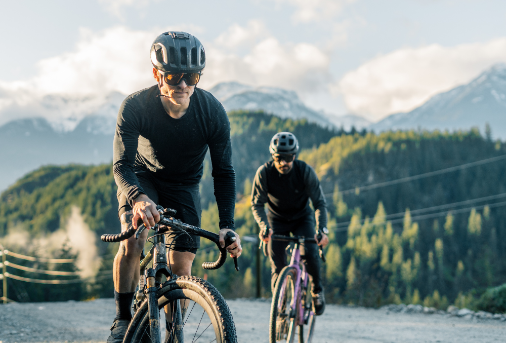 Two cyclists wear helmets and VALLON Watchtowers shield sunglasses made with ZEISS lens tech