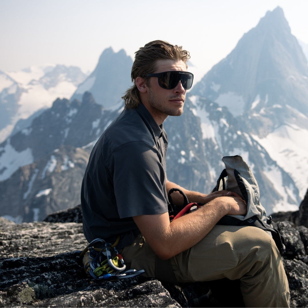 Man wears Black-Smoke Watchtowers sunglasses from VALLON for mountain climbing in summer
