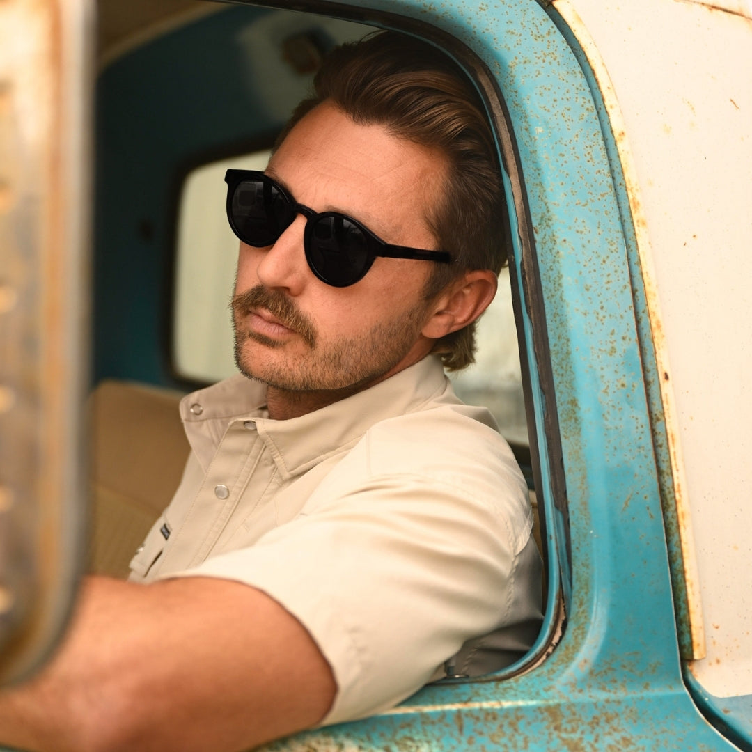 Man in truck wearing Waylons round sunglasses from VALLON with premium acetate frame