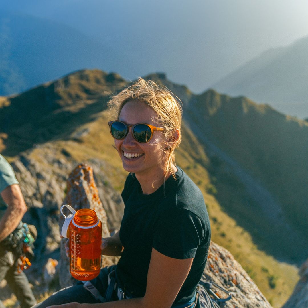 Female mountaineer wears VALLON Waylons Rx sunglasses on a peak